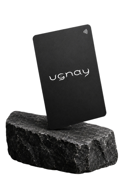 Matte black Ugnay NFC card leaning on a stone base